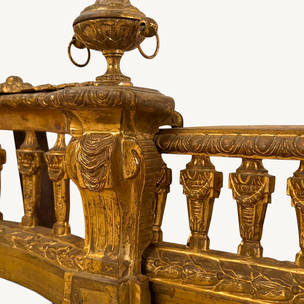 KLS Vaults Louis XVI style gilt-bronze fire fender with neoclassical urns, ram's head masks, and laurel leaf borders.