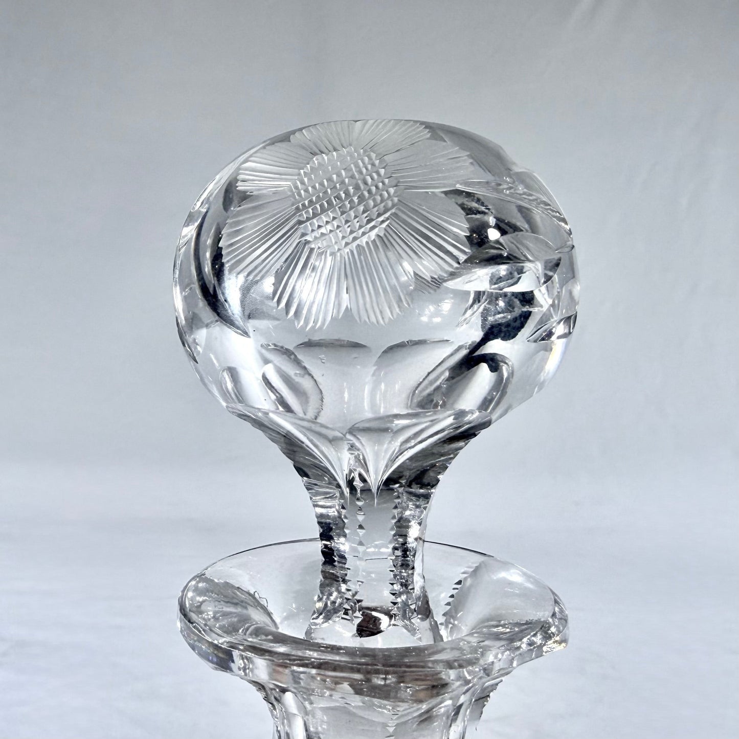KLS Vaults mid-century lead crystal decanter with detailed intaglio floral cut stopper and vertical facet-cut neck.