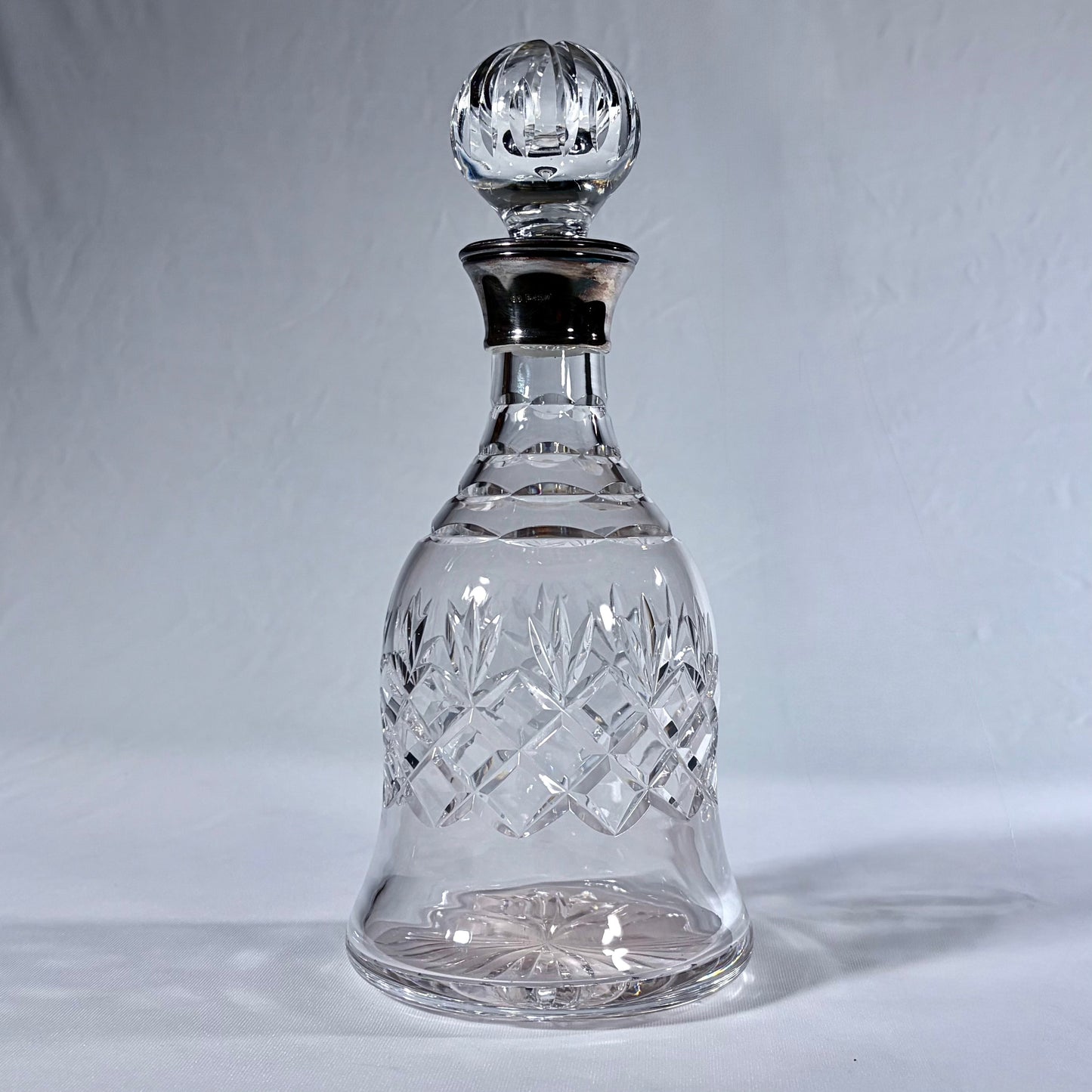 KLS Vaults bell-shaped lead crystal decanter with diamond-cut patterns and a polished sterling silver collar.