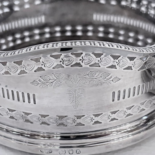 KLS Vaults pair of 1936 sterling silver wine coasters with intricate pierced fretwork and engraved foliate motifs.