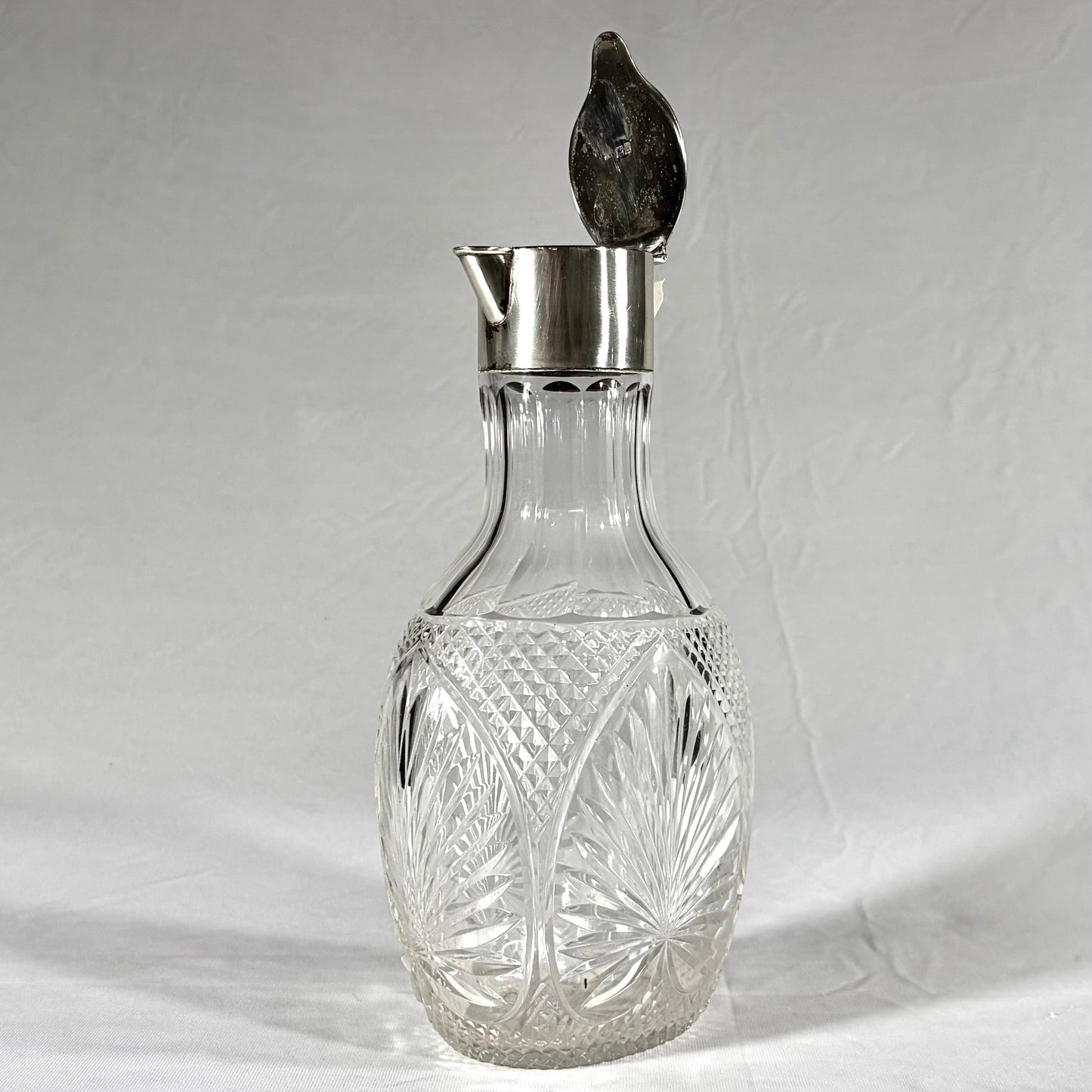 KLS Vaults Victorian claret jug with diamond-cut crystal body and sterling silver hinged lid, London 1896.