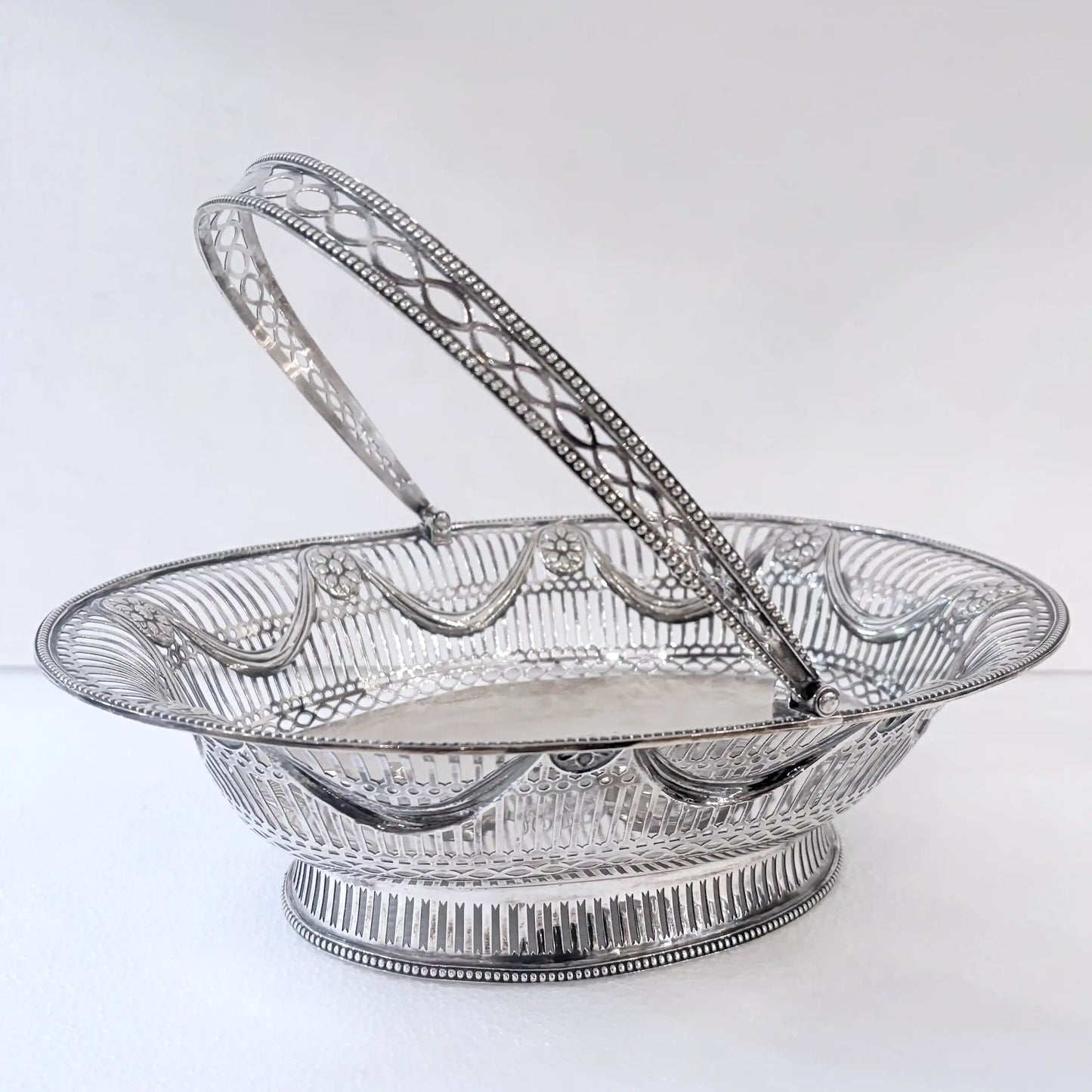 EDWARDIAN PIERCED STERLING SILVER SWING-HANDLED BASKET, LONDON, 1912