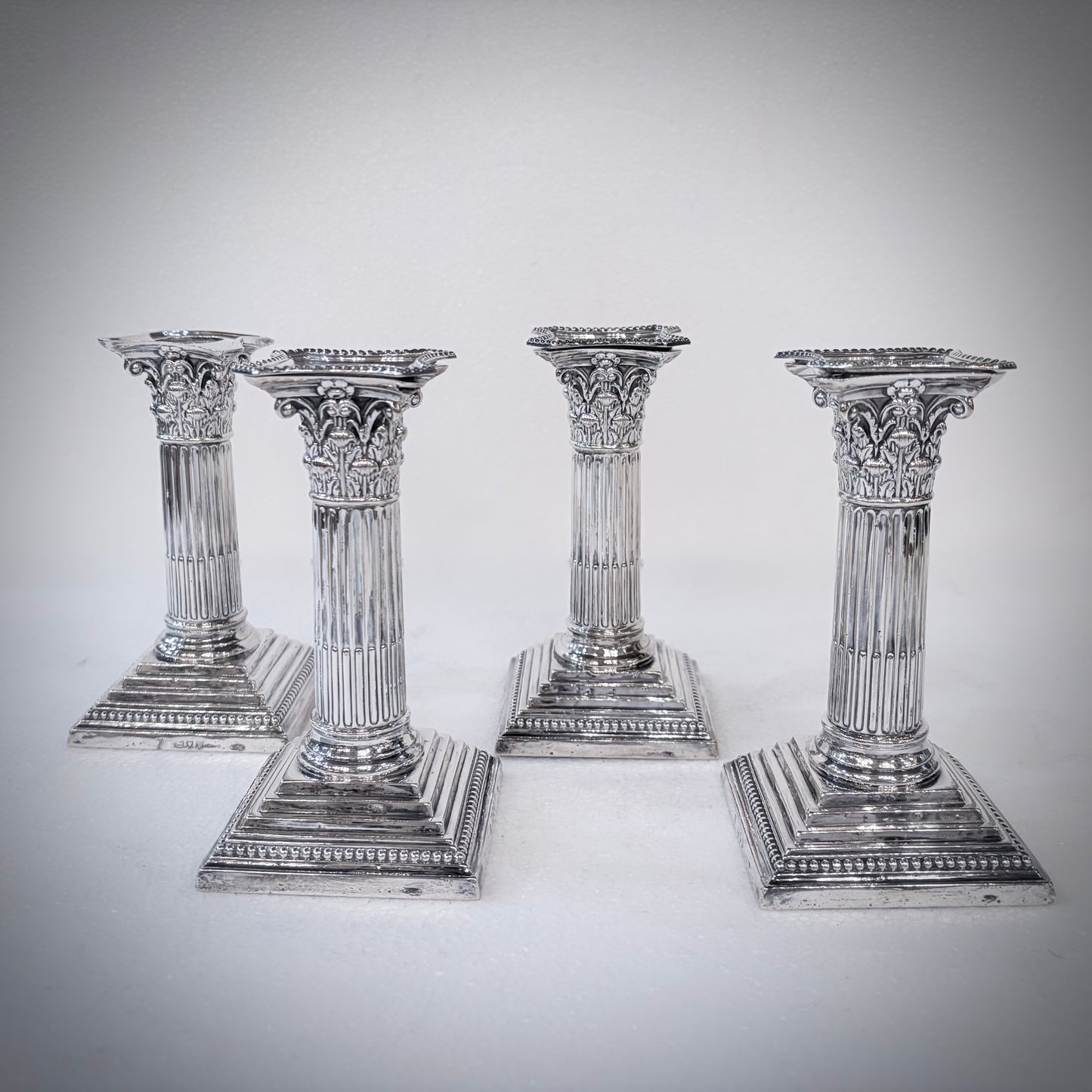 SET OF FOUR LATE VICTORIAN CORINTHIAN COLUMN STERLING SILVER CANDLESTICKS, LONDON, 1893