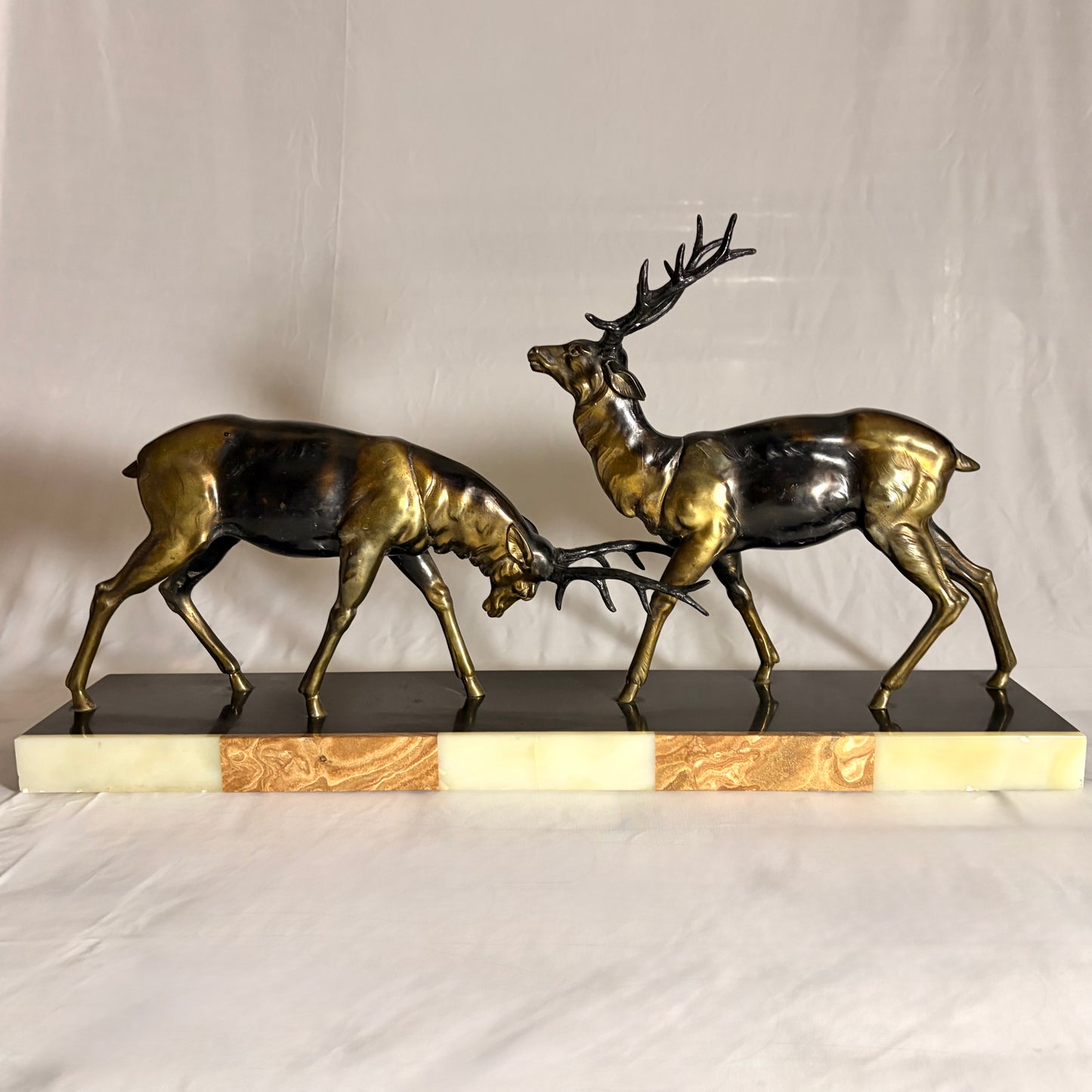 AN ART DECO PATINATED METAL GROUP OF TWO RUTTING STAGS, FRANCE, c. 1900–1930