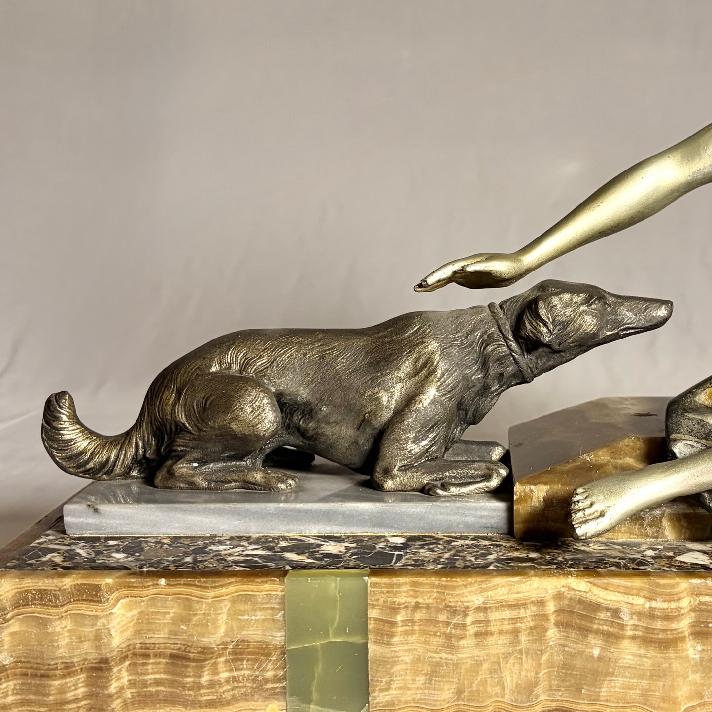 AN ART DECO FIGURAL GROUP OF A SEATED LADY WITH TWO HOUNDS, FRANCE, C.1920s