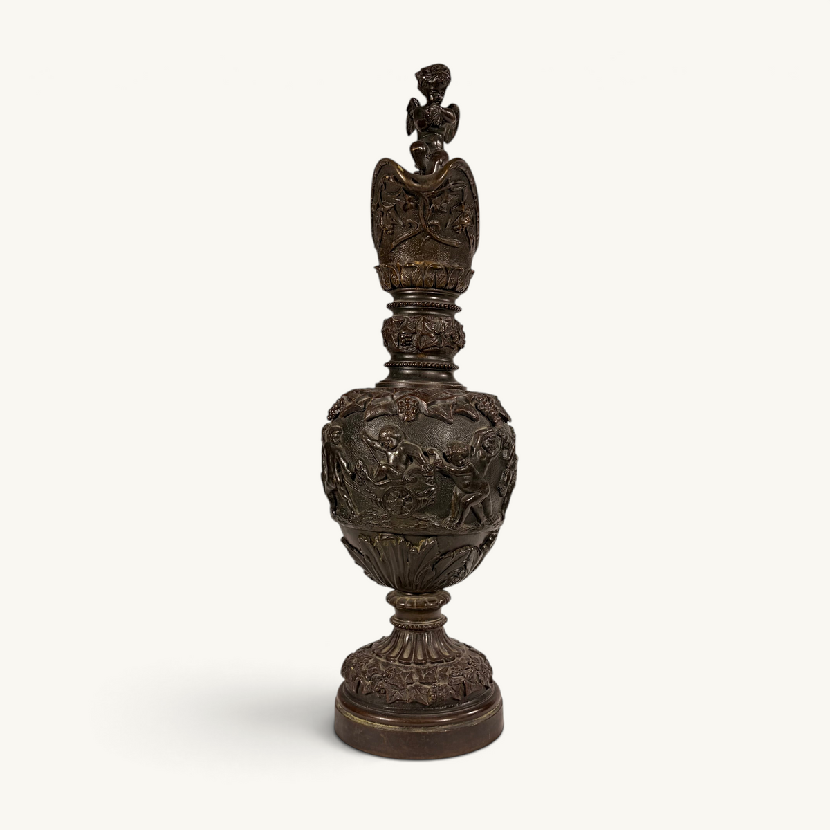 KLS Vaults neoclassical bronze ewer with high-relief putti frieze, winged cherub finial, and chocolate-brown patina.