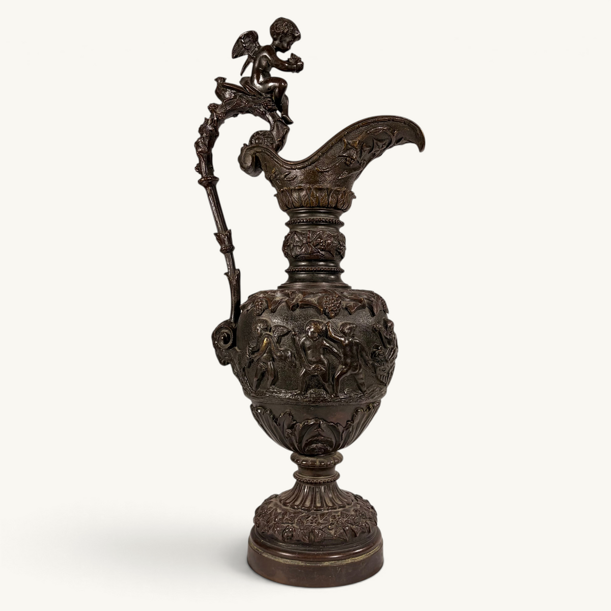 KLS Vaults 19th-century neoclassical bronze ewer with high-relief putti frieze, winged cherub finial, and brown patina.