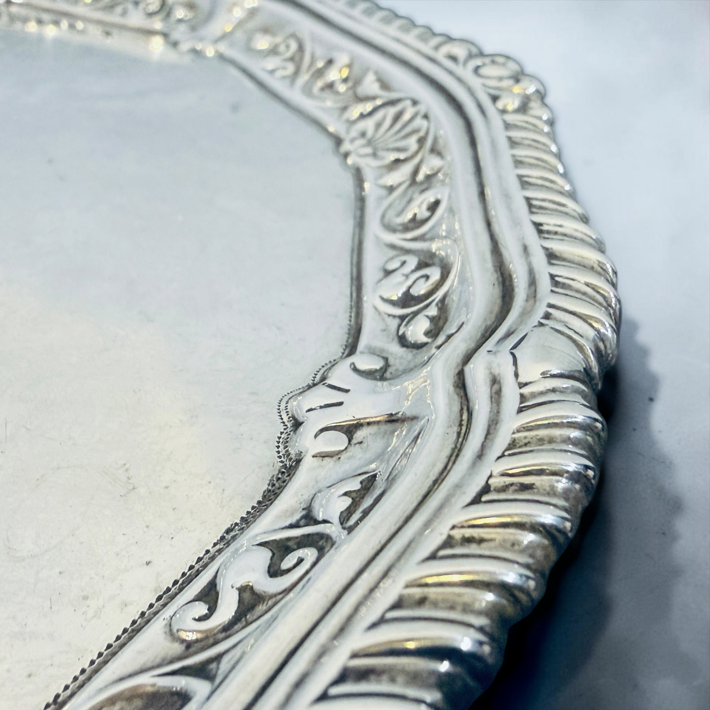 AN ENGRAVED AND GADROONED STERLING SILVER SALVER, LONDON, 1910