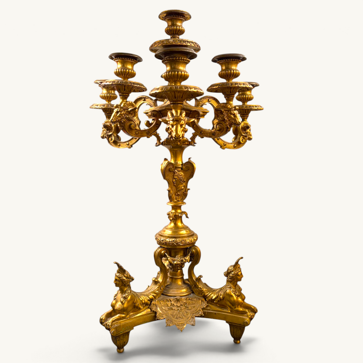 KLS Vaults 19th-century French gilt-bronze candelabrum featuring sphinxes, Roman emperor profiles, and ram-head arms.