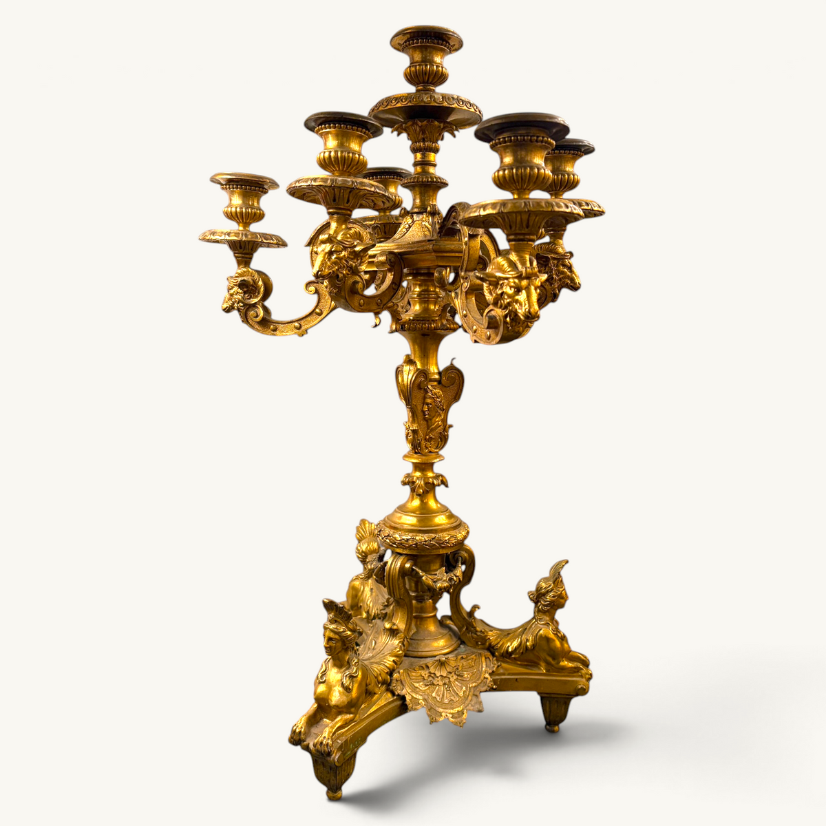 KLS Vaults 19th-century French gilt-bronze candelabrum featuring winged sphinxes, Roman emperor motifs, and ram heads.