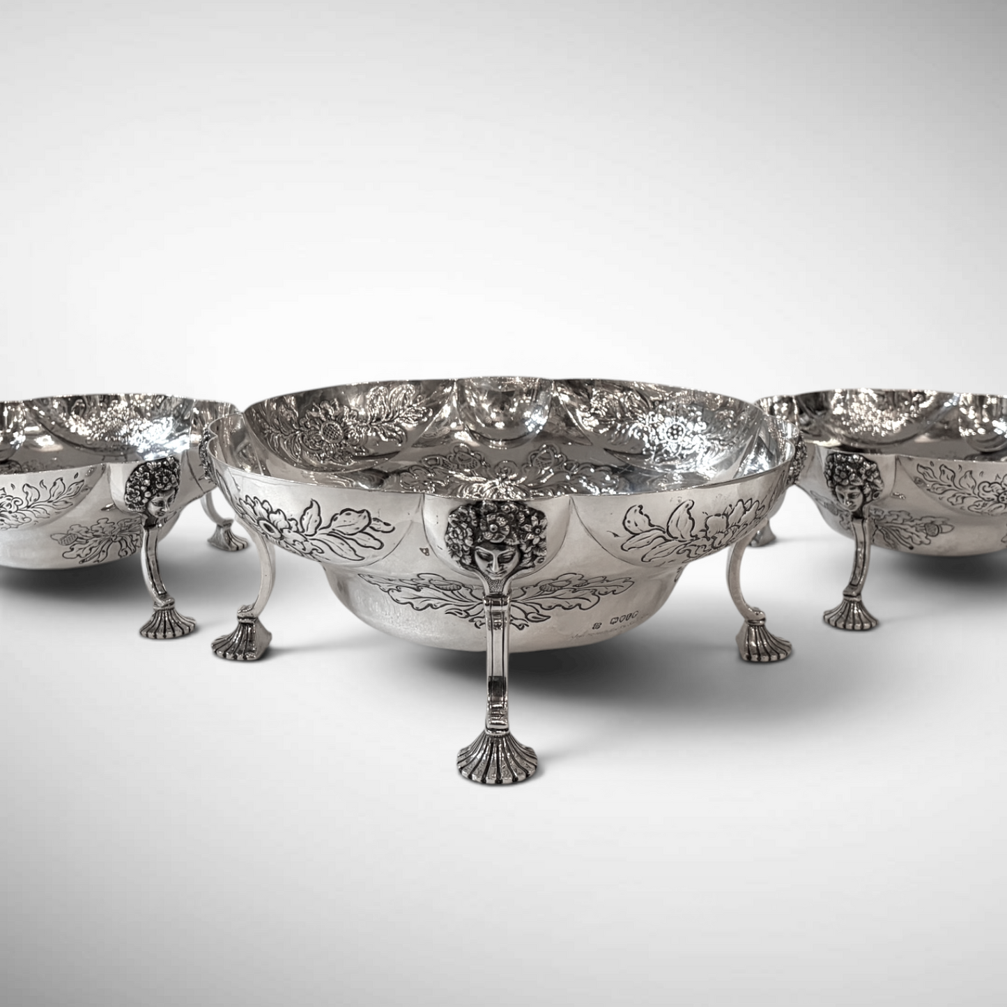 A SET OF THREE LATE VICTORIAN REPOUSSÉ STERLING SILVER CENTERPIECES, LONDON, 1889