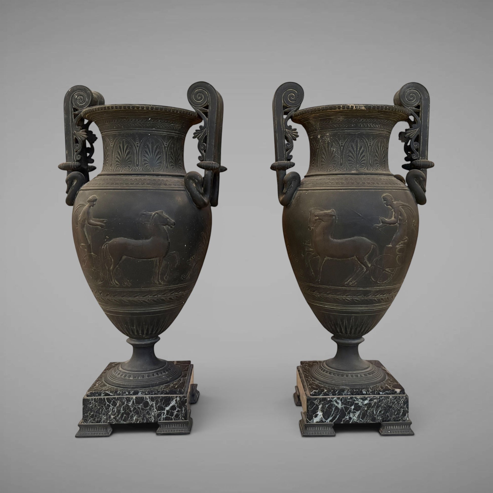 KLS Vaults pair of 19th-century French ovoid urns with dark Pompeian patina, swan-neck handles, and marble plinths.