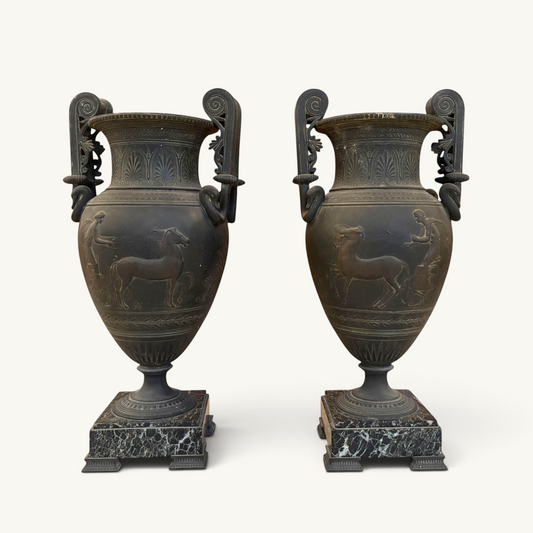 KLS Vaults pair of 19th-century French ovoid urns with dark Pompeian patina, swan-neck handles, and marble plinths.