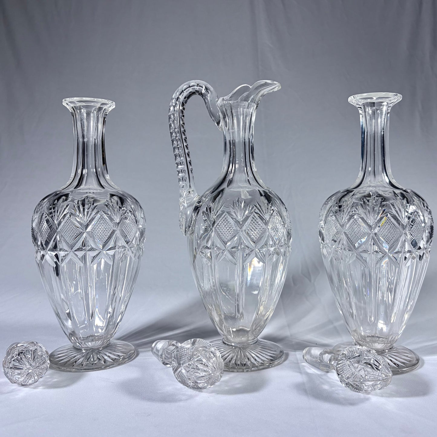 KLS Vaults 19th-century cut-glass decanter and claret jug set with diamond-cut patterns and original stoppers.