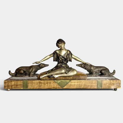 KLS Vaults Art Deco spelter figural group of a seated woman with two hounds on a decorative onyx and marble plinth.