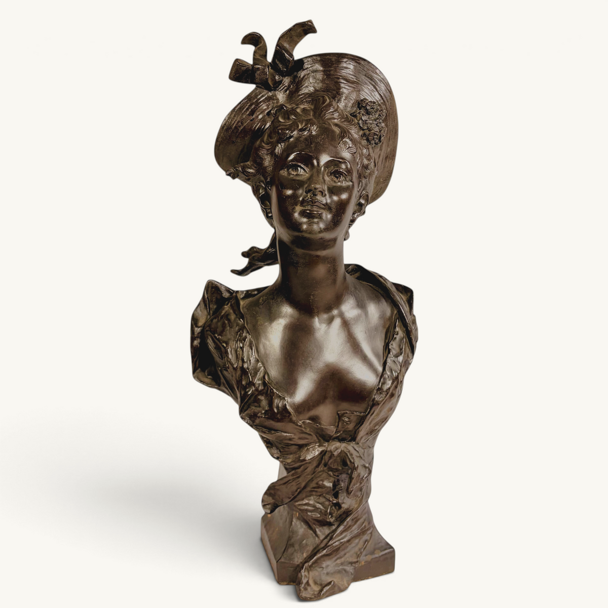 KLS Vaults patinated bronze bust of a young woman in an elaborate hat, Art Nouveau style, late 19th century.