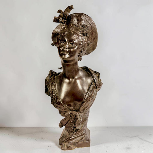 KLS Vaults patinated bronze bust of a young woman in an elaborate hat, Art Nouveau style, late 19th century.