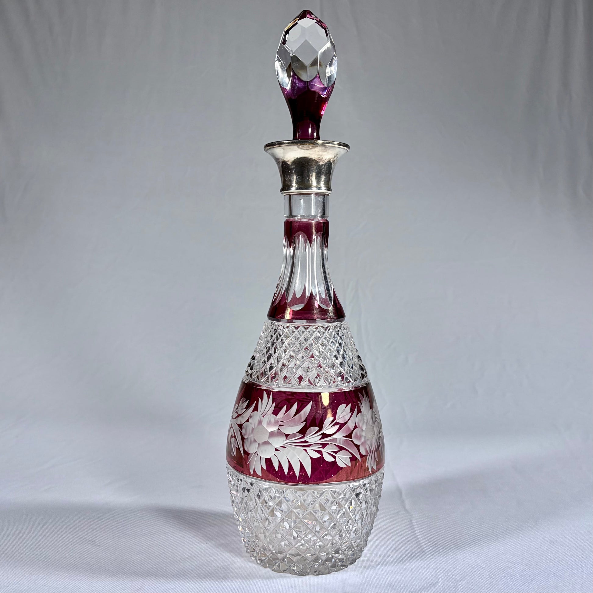KLS Vaults Bohemian glass decanter with cranberry flash overlay, floral engraving, and sterling silver collar, 1973.