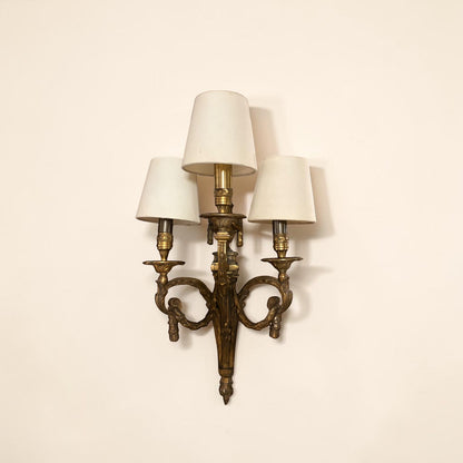 KLS Vaults pair of Louis XVI style bronze wall sconces featuring ram's head motifs, laurel swags, and three light shades.