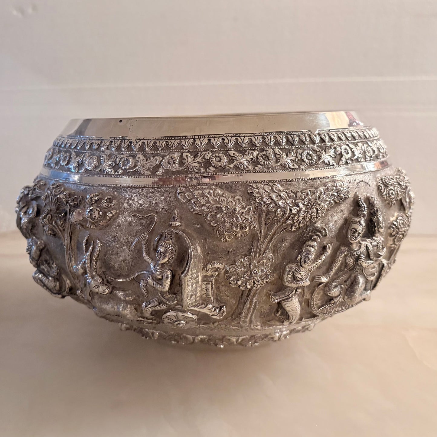 KLS Vaults 19th-century Burmese silver thabeik bowl featuring high-relief repoussé Ramayana scenes and floral borders.