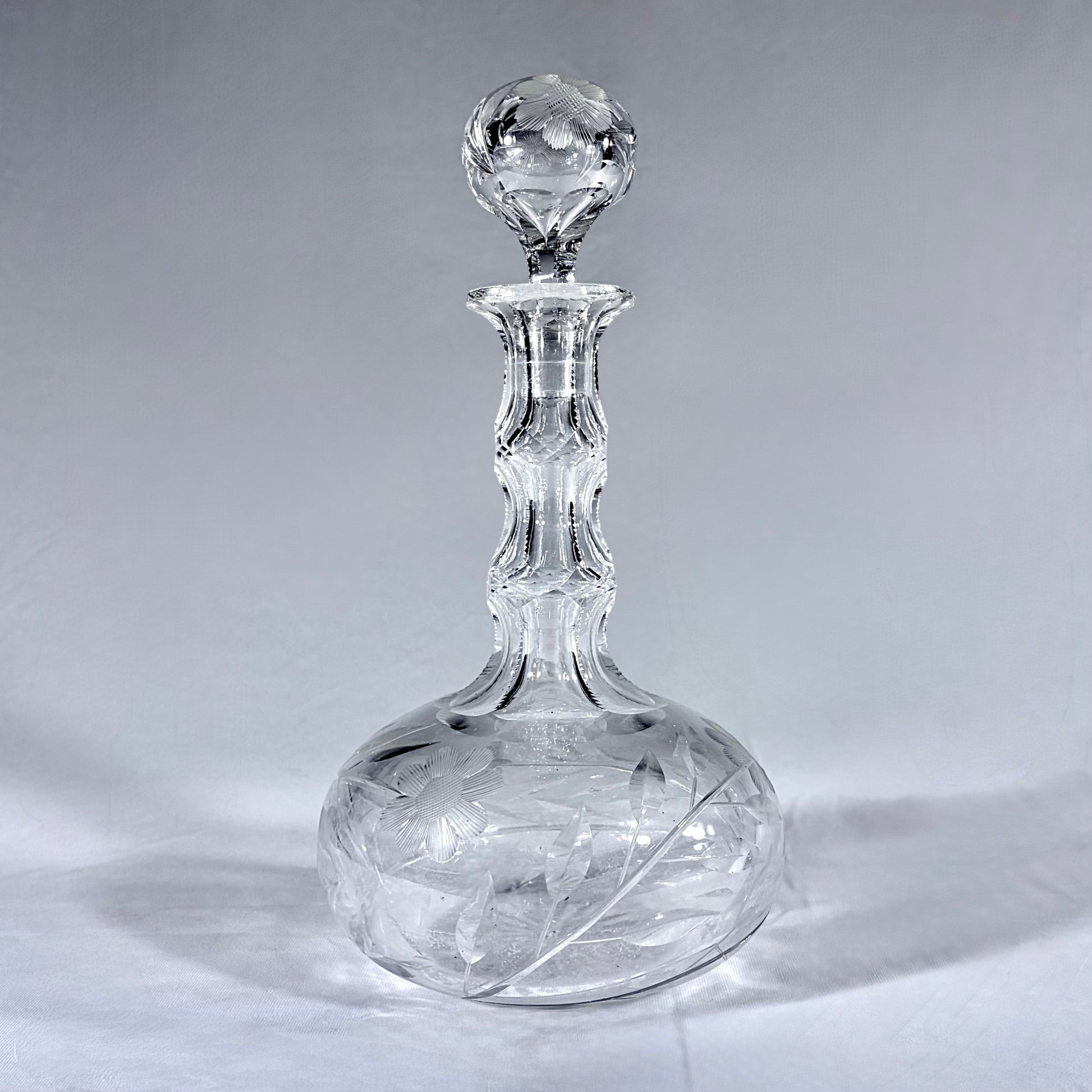 KLS Vaults mid-century lead crystal wine decanter with hand-cut floral intaglio, faceted neck, and sphere stopper.