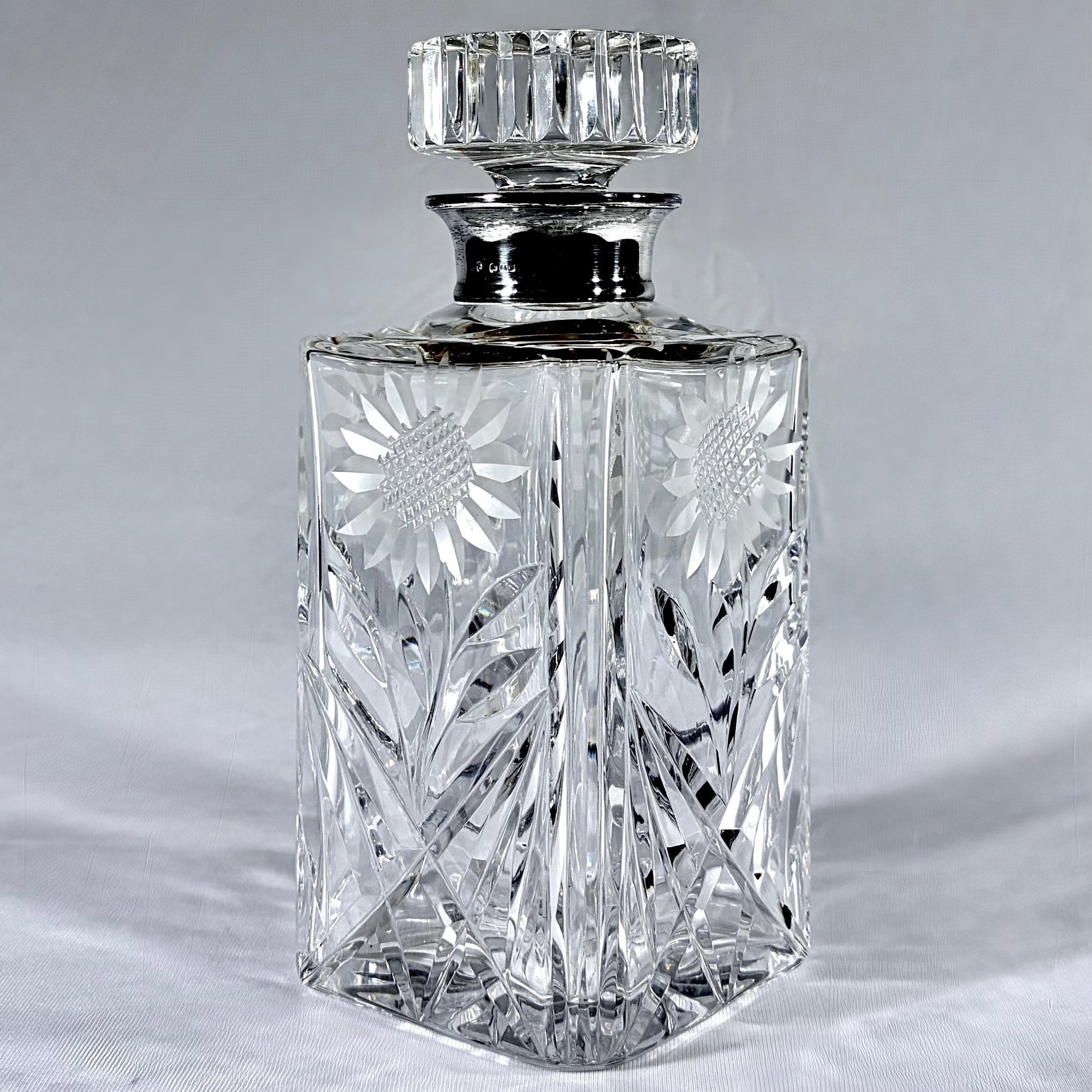 KLS Vaults mid-century cut-glass decanter with sterling silver collar, sunflower engraving, and faceted stopper.