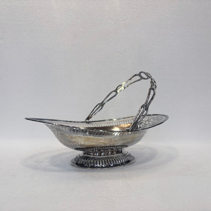 KLS Vaults Edwardian sterling silver fruit basket with pierced gallery, foliate scrollwork, and swing handle, 1905.