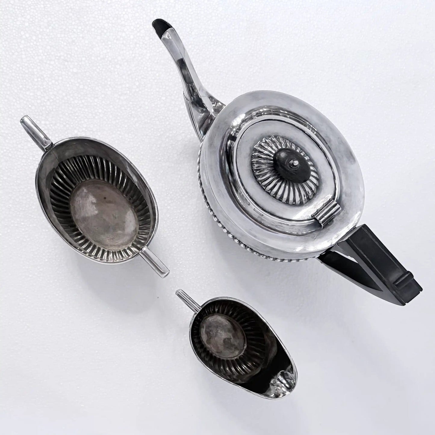 KLS Vaults Edwardian sterling silver three-piece tea service with gadrooned bodies and ebonized wood handles.