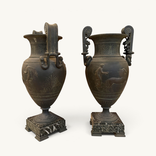 KLS Vaults pair of 19th-century French urns with dark Pompeian patina, swan-neck handles, and marble plinths.