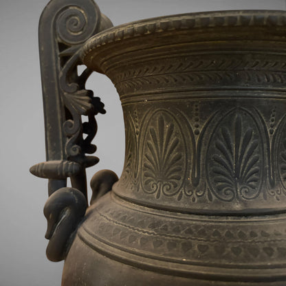 KLS Vaults 19th-century French urn featuring dark Pompeian patina, swan-neck volute handles, and palmette relief details.