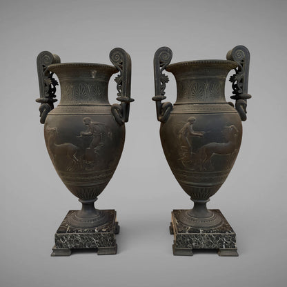KLS Vaults pair of 19th-century French urns with dark Pompeian patina, swan-neck handles, and marble plinths.