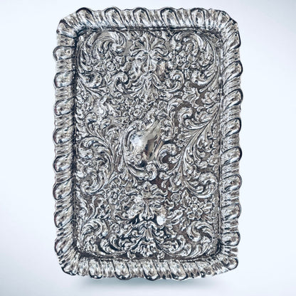 KLS Vaults 1927 George V sterling silver dressing tray with ornate repoussé floral scrolls and Green Man mask motifs.
