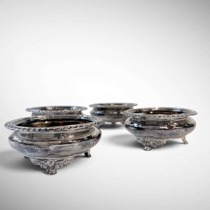 KLS Vaults set of four 1823 sterling silver salt cellars with gadrooned rims and ornate lion-mask paw feet.