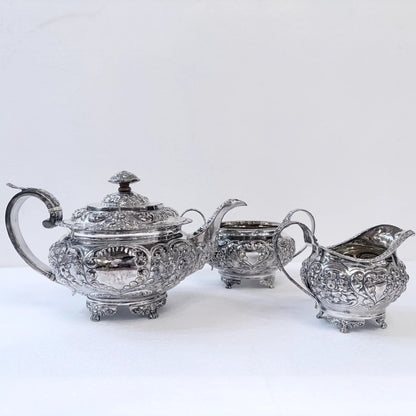 KLS Vaults 1822 sterling silver three-piece tea service with ornate repoussé floral and acanthus leaf chasing.