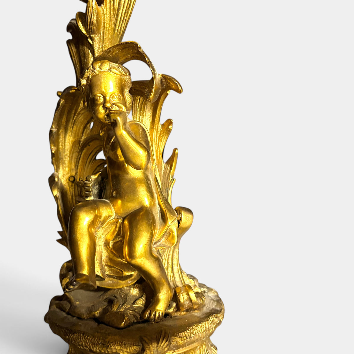 KLS Vaults 19th century Louis XV style gilt bronze candelabra featuring a seated putto and ornate acanthus foliage