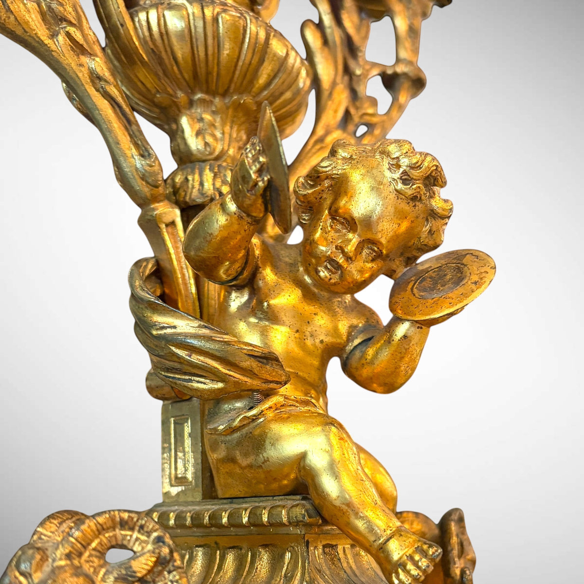 KLS Vaults 19th-century gilt-bronze candelabra featuring a detailed putto playing cymbals on a neoclassical base.