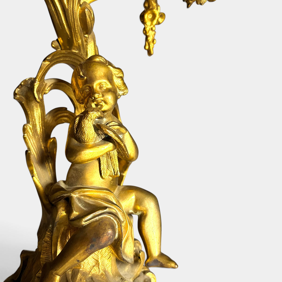 KLS Vaults 19th century Louis XV style gilt bronze candelabrum featuring a seated putto holding a bird
