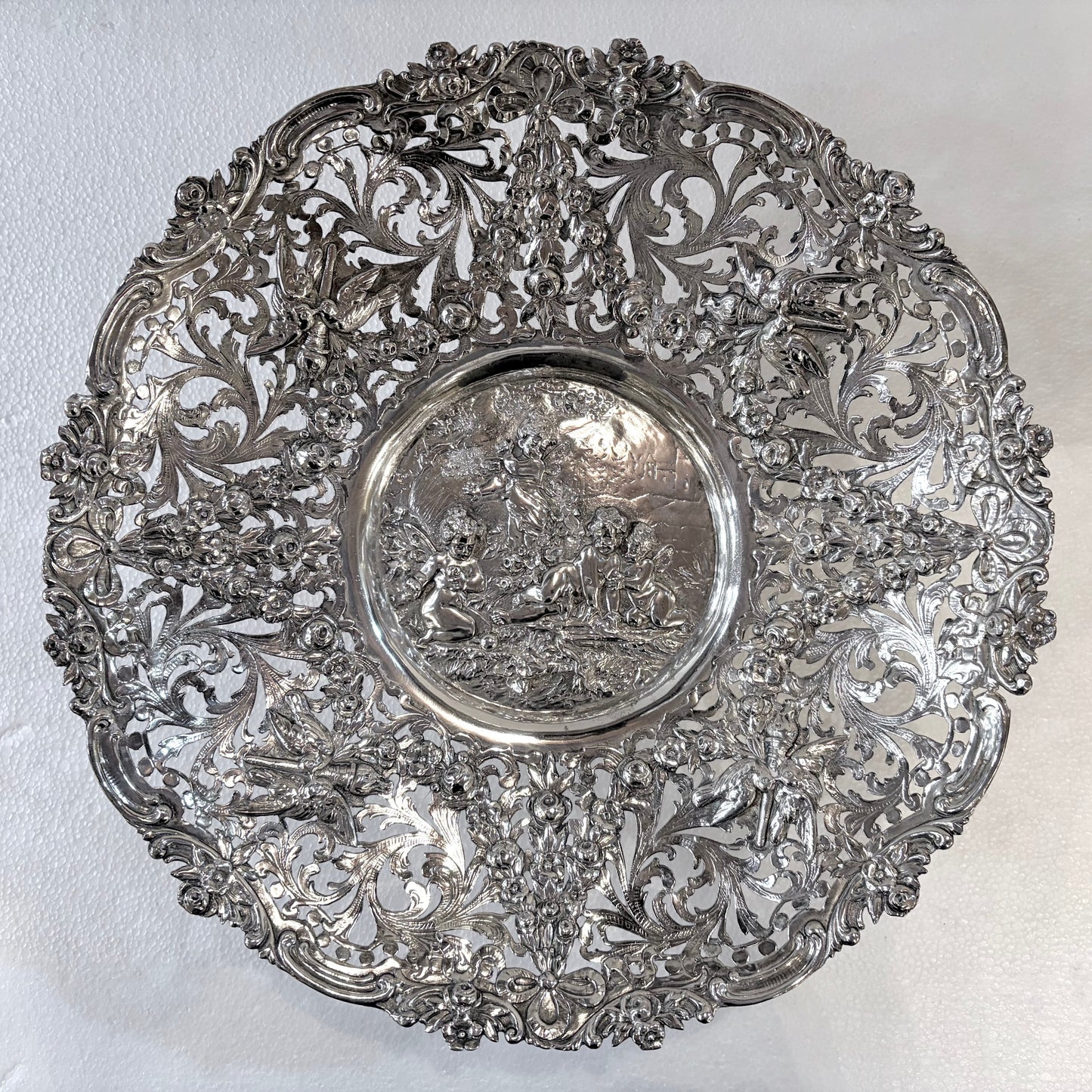 KLS Vaults 19th-century Hanau silver tazza with intricate reticulated floral scrolls and a central putti medallion.