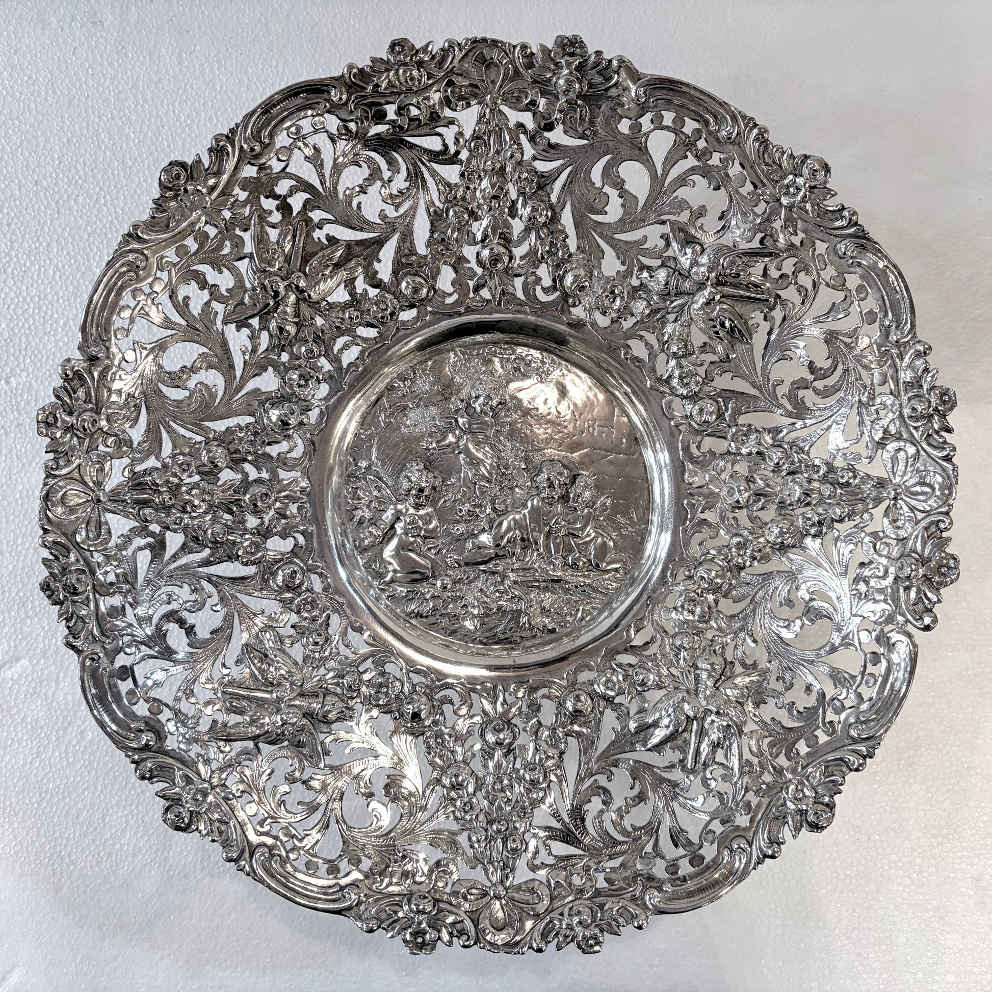 KLS Vaults 19th-century Hanau silver tazza with intricate reticulated floral scrolls and a central putti medallion.