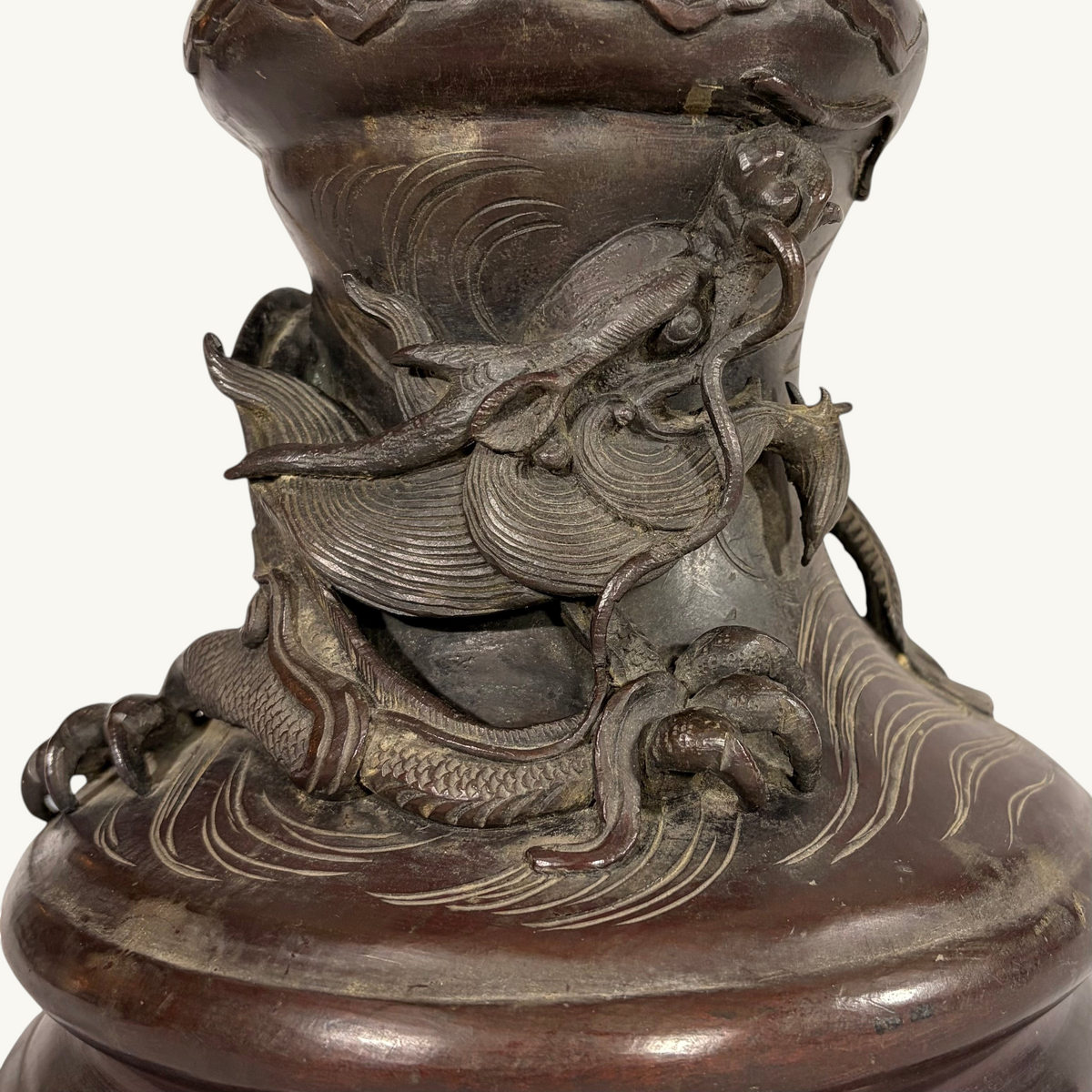 KLS Vaults Japanese Meiji period bronze vase featuring a detailed relief sculpture of a dragon coiling over waves.