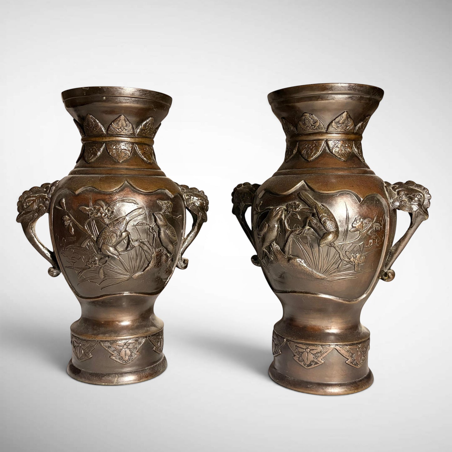 KLS Vaults pair of Meiji period bronze vases featuring high relief kingfisher and lotus designs with rooster-head handles.