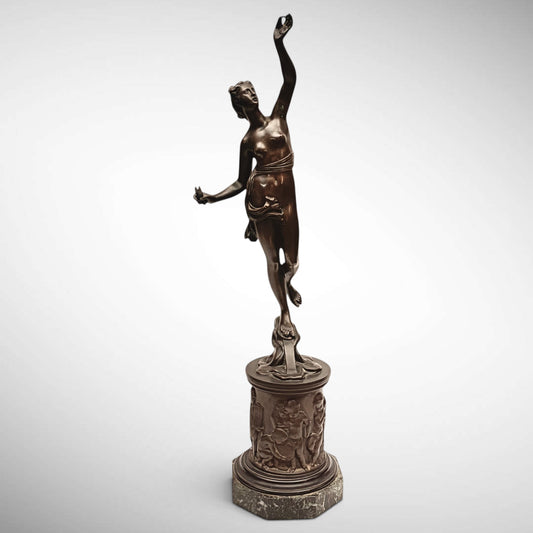 KLS Vaults neoclassical patinated bronze figure of Atropos with shears, standing on a relief-cast pedestal and plinth.