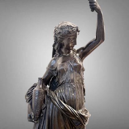 KLS Vaults 19th century Neoclassical patinated bronze figure of Hebe with flowing drapery and etched lekythos vase.