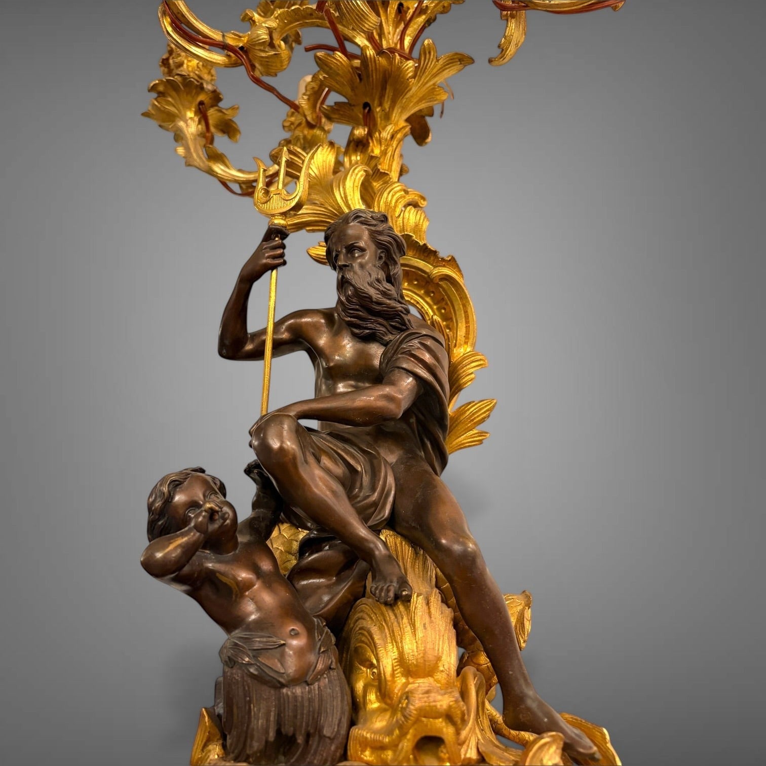 KLS Vaults 19th-century French gilt bronze candelabra featuring Neptune and Triton figures with foliate scroll arms.