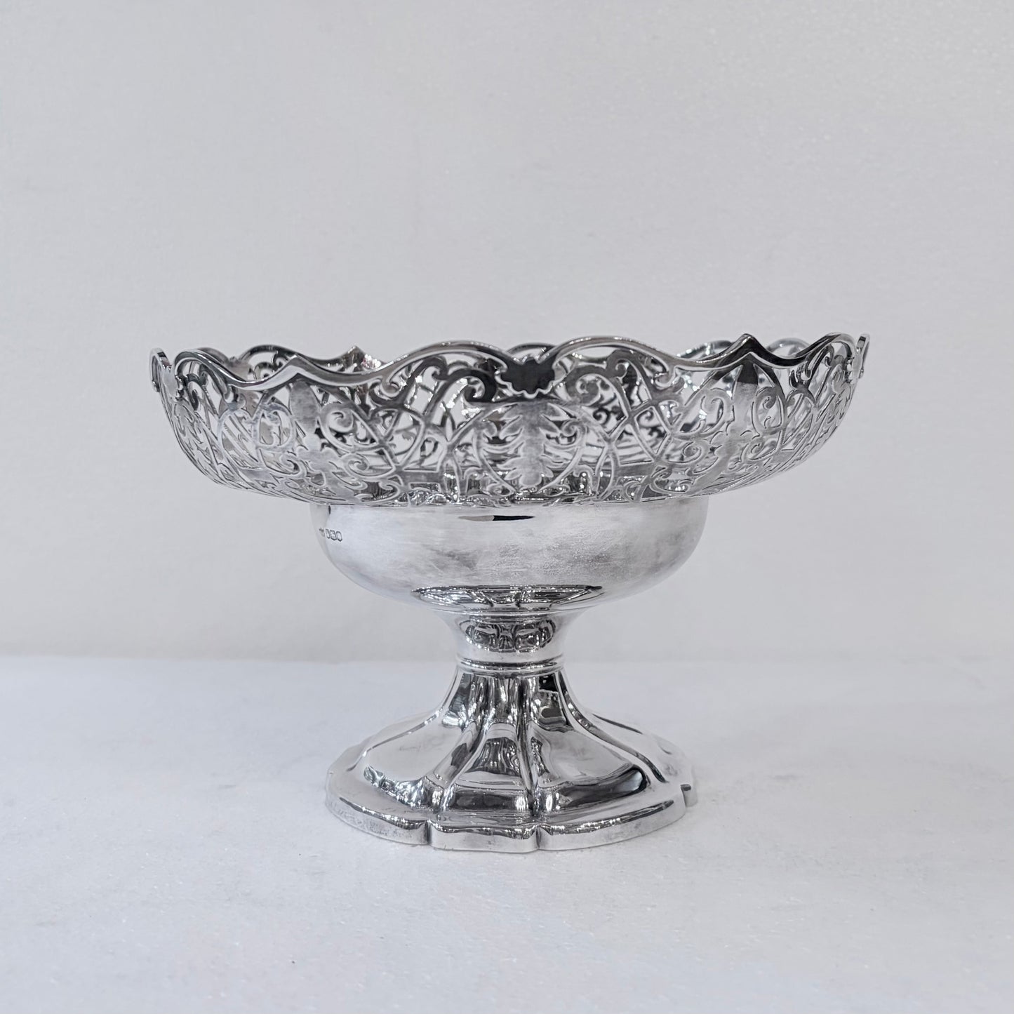 KLS Vaults 1935 sterling silver centerpiece bowl with intricate pierced scrollwork and a scalloped rim on a pedestal.