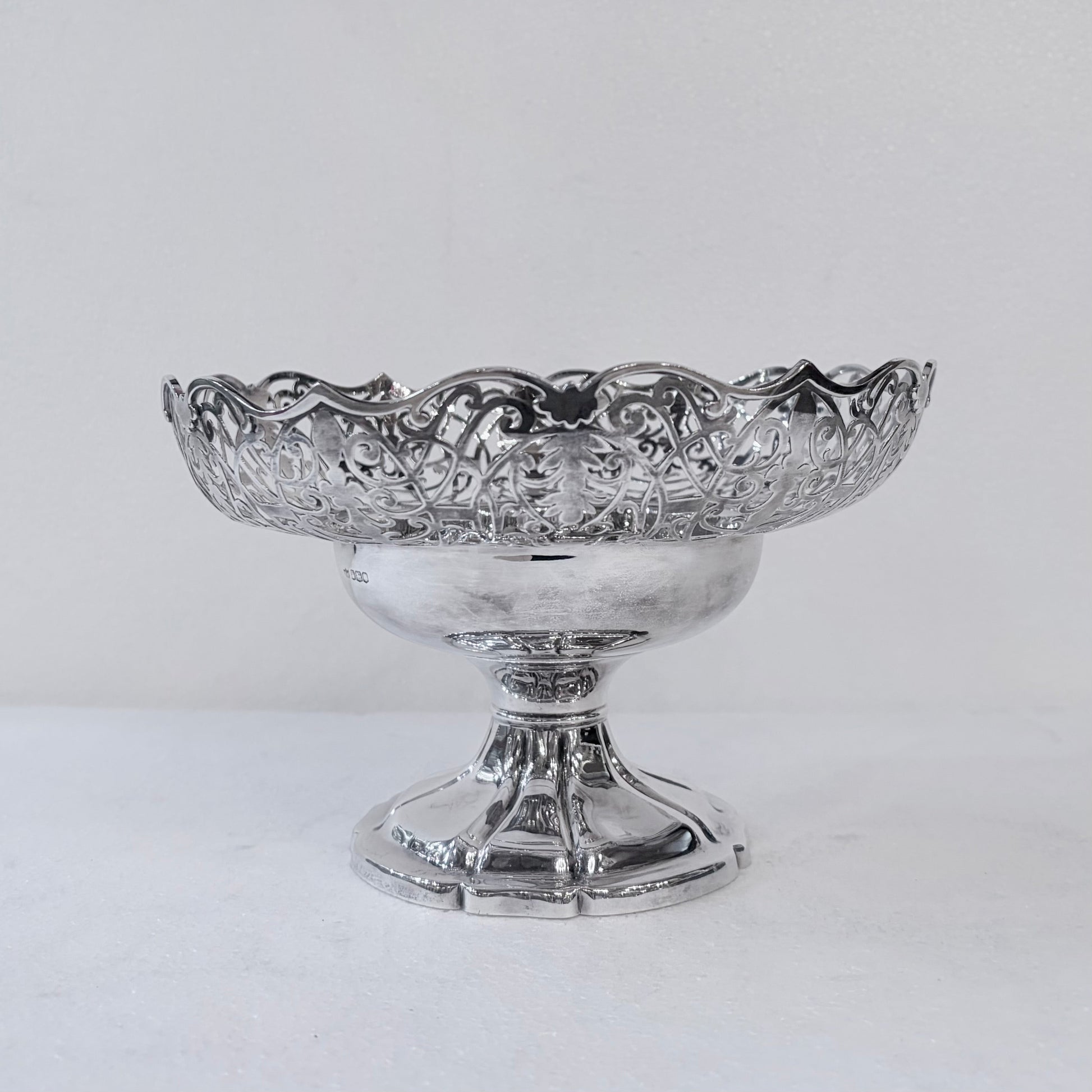 KLS Vaults 1935 sterling silver centerpiece bowl with intricate pierced scrollwork and a scalloped rim on a pedestal.