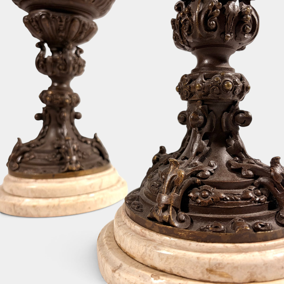 KLS Vaults pair of 19th-century Rococo Revival patinated bronze ewers with intricate floral detail on marble bases.