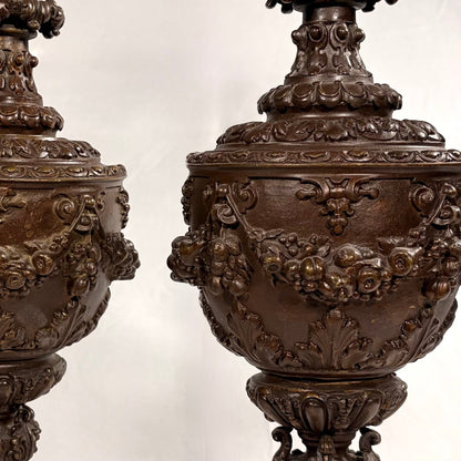 KLS Vaults pair of 19th-century Rococo Revival patinated bronze ewers with intricate fruit and floral garland relief.