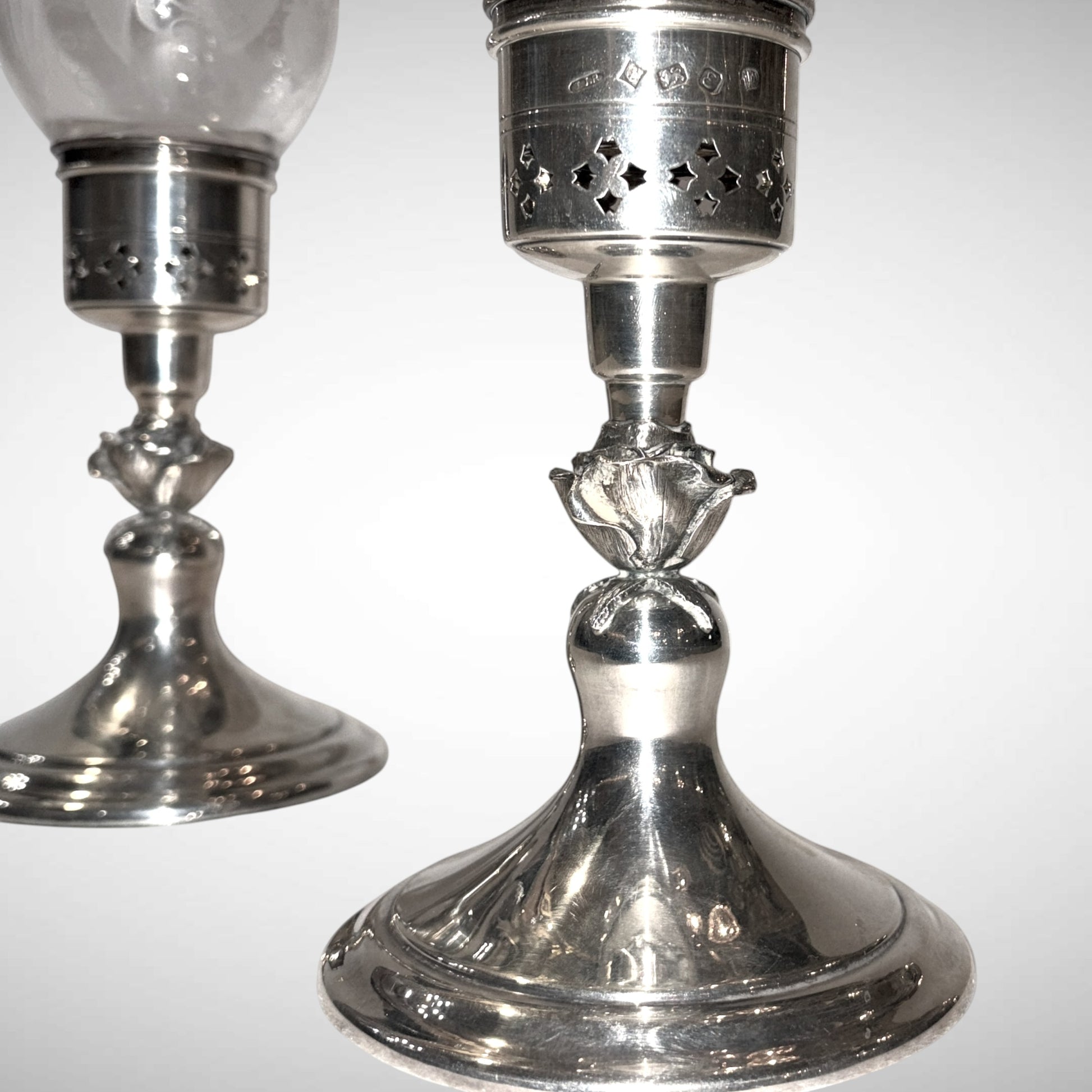 KLS Vaults pair of 1979 Elizabeth II silver hurricane lamps with pierced geometric stars and floral rose stems.