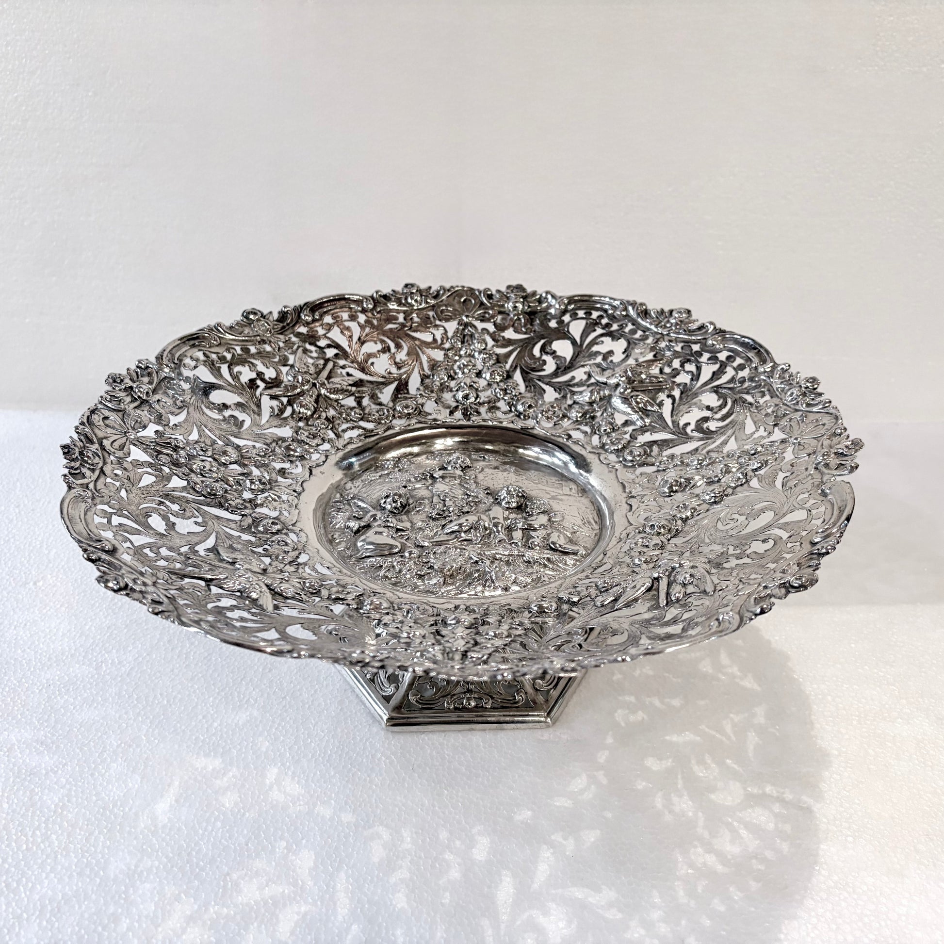 KLS Vaults 800 silver Neo-Renaissance tazza with intricate pierced floral scrolls and a central putti medallion.